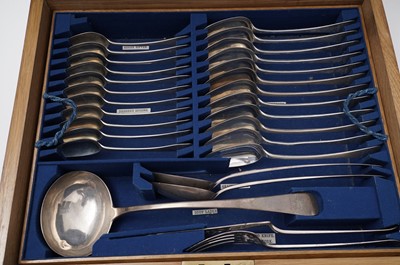 Lot 443 - A canteen of flatware and cutlery in a fitted oak case; with two matching basting spoons