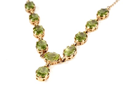 Lot 340 - A peridot and yellow gold necklace and earrings
