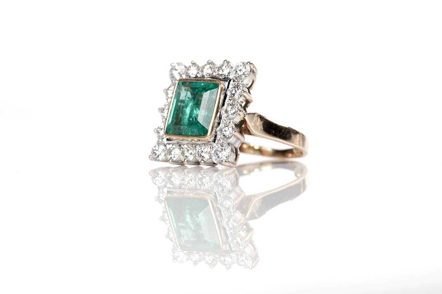 Lot 1174 - An emerald and diamond cluster ring