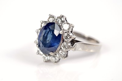 Lot 1184 - A sapphire and diamond cluster ring