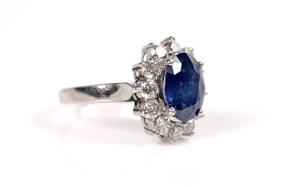 Lot 1184 - A sapphire and diamond cluster ring