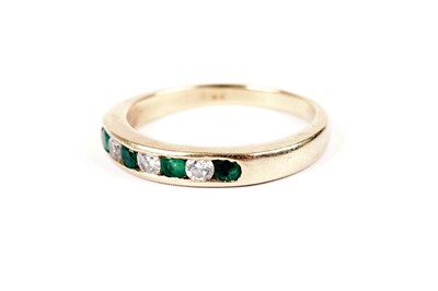 Lot 547 - An emerald and diamond half hoop eternity ring