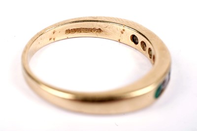 Lot 547 - An emerald and diamond half hoop eternity ring