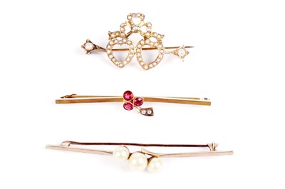 Lot 607 - Three bar brooches, including an Edwardian garnet and seed pearl cherry brooch