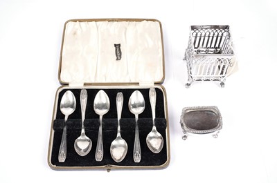 Lot 777 - A set of six George V silver teaspoons; a silver salt cellar; and a silver reticulated pot