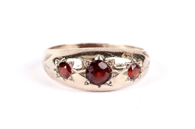 Lot 521 - A garnet three stone band; and another garnet ring