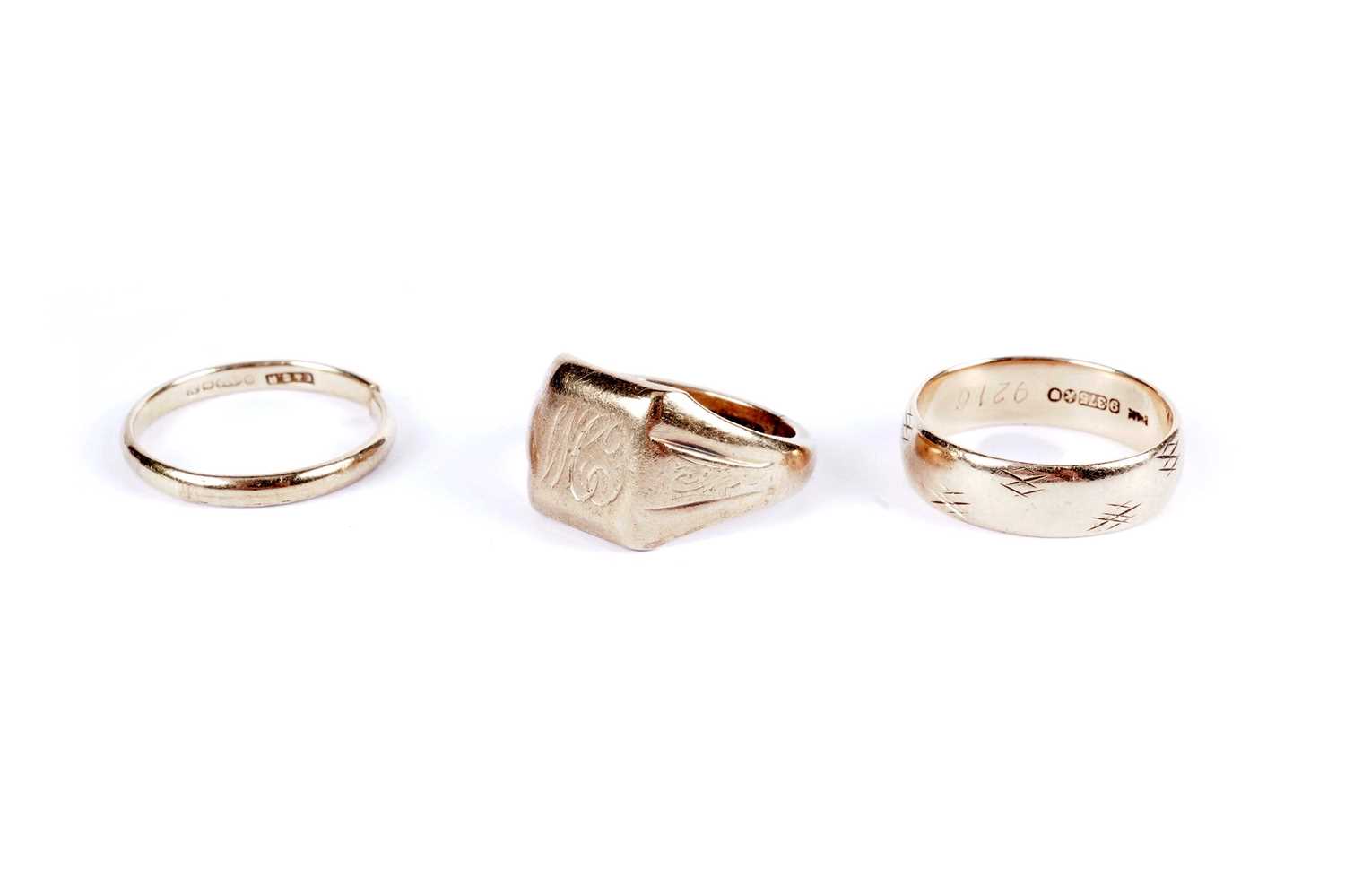 Lot 573 - Two 9ct yellow gold wedding bands; and a signet ring