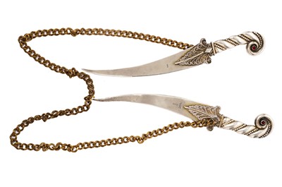 Lot 807 - Two Palestinian silver letter knives on a gilt metal chain