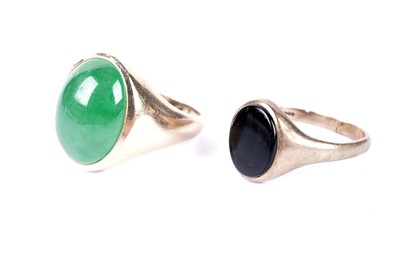 Lot 209 - An onyx signet ring and a jadeite cabochon signet ring