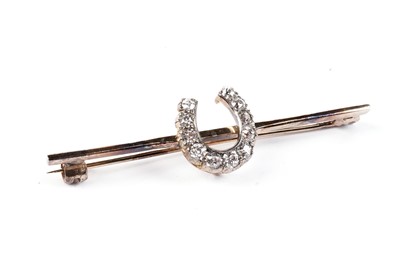 Lot 576 - A diamond lucky horseshoe bar brooch