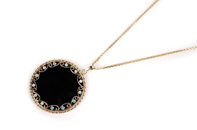 Lot 1104 - An onyx and opal pendant on chain