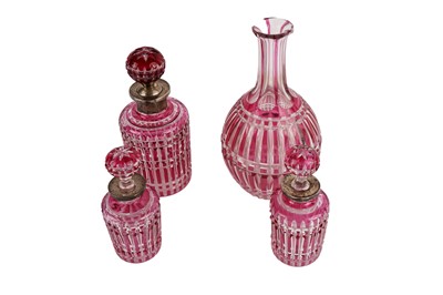 Lot 294 - A set of three Victorian cranberry flash glass decanters and stopper and another