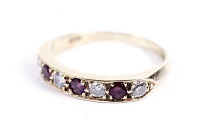 Lot 71 - A ruby and diamond half-hoop eternity ring