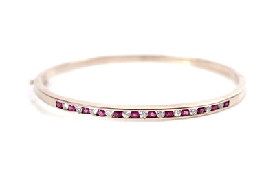 Lot 1280 - A ruby and diamond bangle