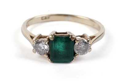 Lot 632 - An emerald and diamond three-stone ring