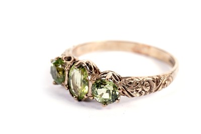 Lot 435 - A three-stone peridot ring