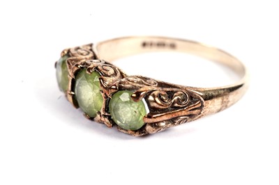 Lot 444 - A three-stone peridot ring