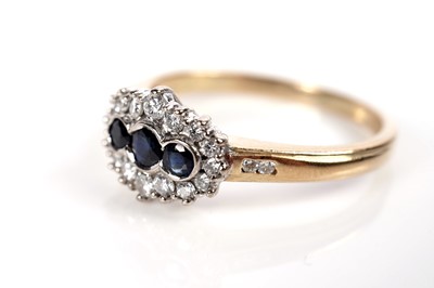 Lot 1233 - A sapphire and diamond cluster ring