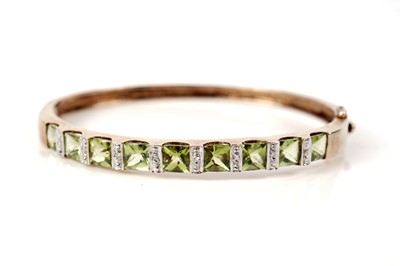 Lot 1238 - A peridot and diamond bangle