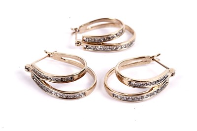 Lot 591 - A trio of diamond and yellow gold hoop earrings