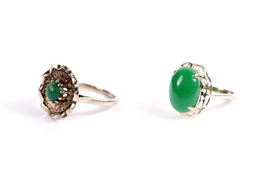 Lot 608 - A jadeite cabochon dress ring; and a green stone flower motif dress ring