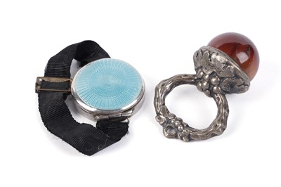 Lot 692 - An agate and silver-coloured metal child's teether; and a silver and enamel wrist compact