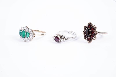 Lot 711 - A garnet and 9ct gold cluster ring; and two other gemstone rings