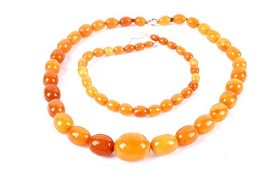 Lot 210 - A butterscotch amber graduated bead necklace; and another string of butterscotch amber