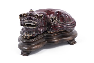 Lot 405 - A Chinese flambe glazed Buddhist lion, on wood stand