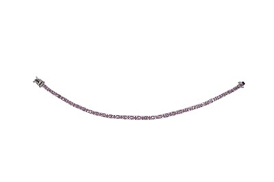 Lot 670 - A diamond and pink sapphire tennis or line bracelet