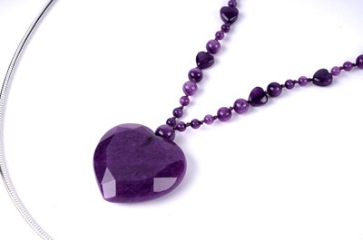 Lot 196 - A Lalique opalescent glass heart pendant; and an amethyst pendant necklace
