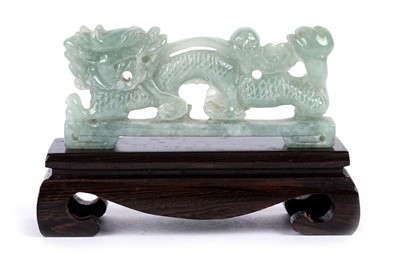 Lot 899 - A pale green jade dragon on stand