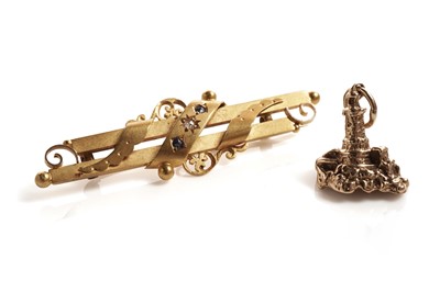 Lot 205 - A sapphire and diamond bar brooch; and a 9ct yellow gold lighthouse pendant