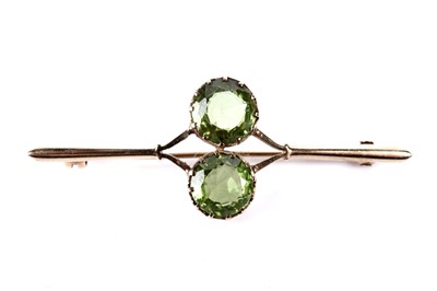 Lot 232 - A peridot and 9ct yellow gold bar brooch