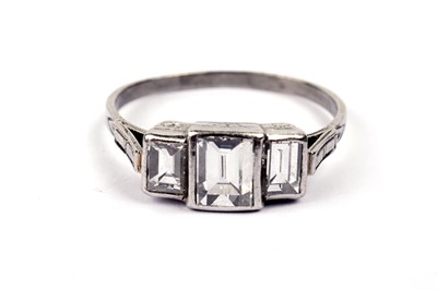 Lot 720 - A three stone baguette-cut diamond ring