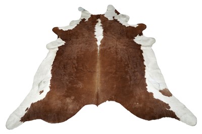 Lot 180 - A white and brown cowhide rug