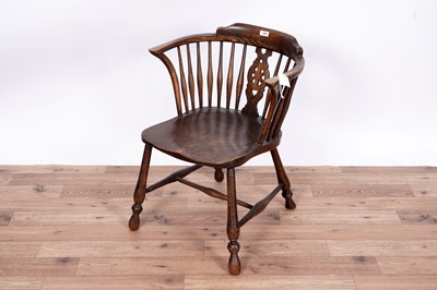 Lot 104 - An early 20th Century beach ash and elm spindle back solid seat armchair