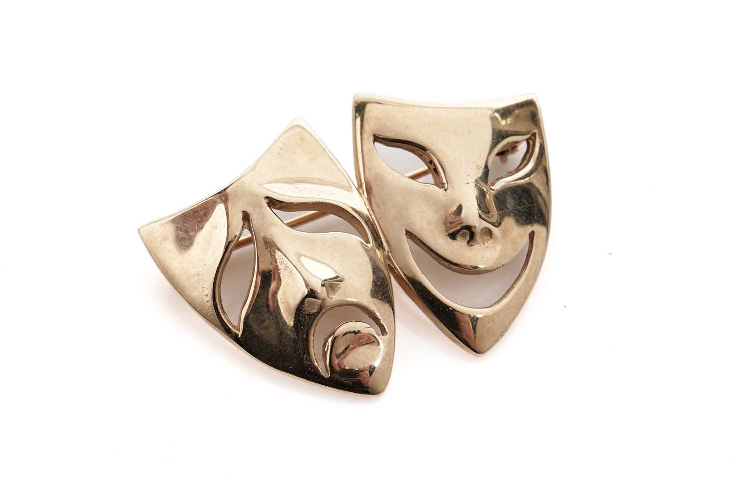 Lot 696 - A 9ct yellow gold mask form brooch