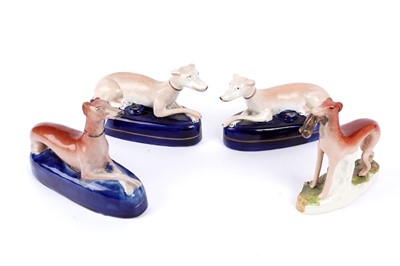 Lot 933 - A pair of Staffordshire greyhound pen holders and another; and a Staffordshire greyhound figure