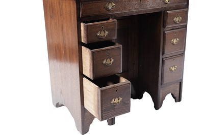 Lot 65 - A George III oak kneehole desk