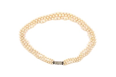 Lot 818 - A triple-row cultured pearl necklace on diamond set clasp