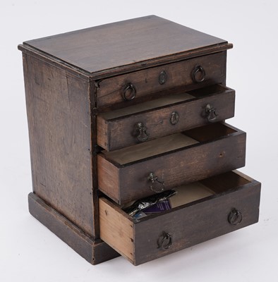Lot 257 - A George III oak miniature chest of drawers
