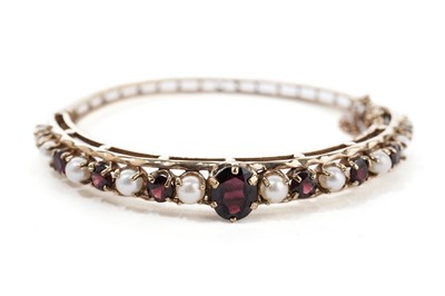 Lot 886 - A garnet and cultured pearl bangle