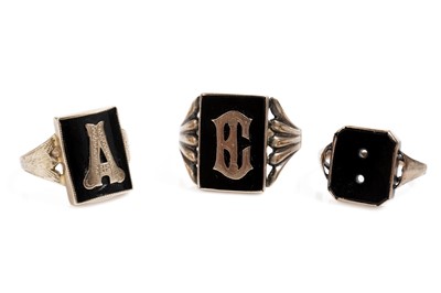 Lot 831 - Three black onyx and yellow gold signet rings, two monogrammed