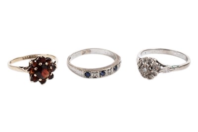 Lot 874 - A diamond flower cluster ring; and two other rings