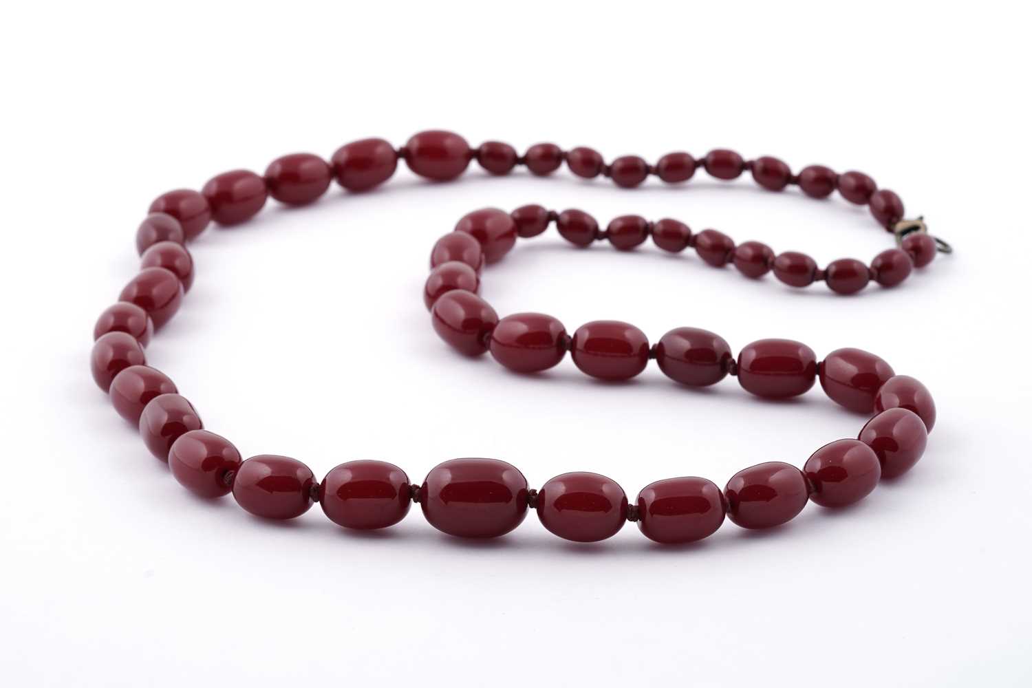 Lot 96 - A cherry amber-style bead necklace; and earrings