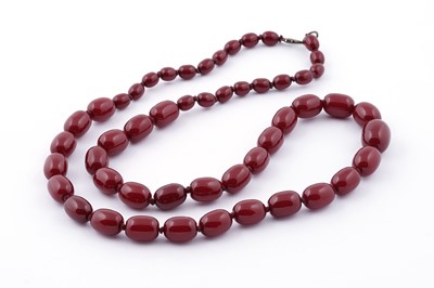 Lot 96 - A cherry amber-style bead necklace; and earrings