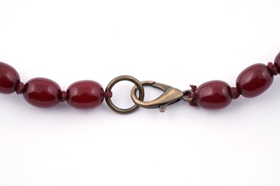 Lot 96 - A cherry amber-style bead necklace; and earrings