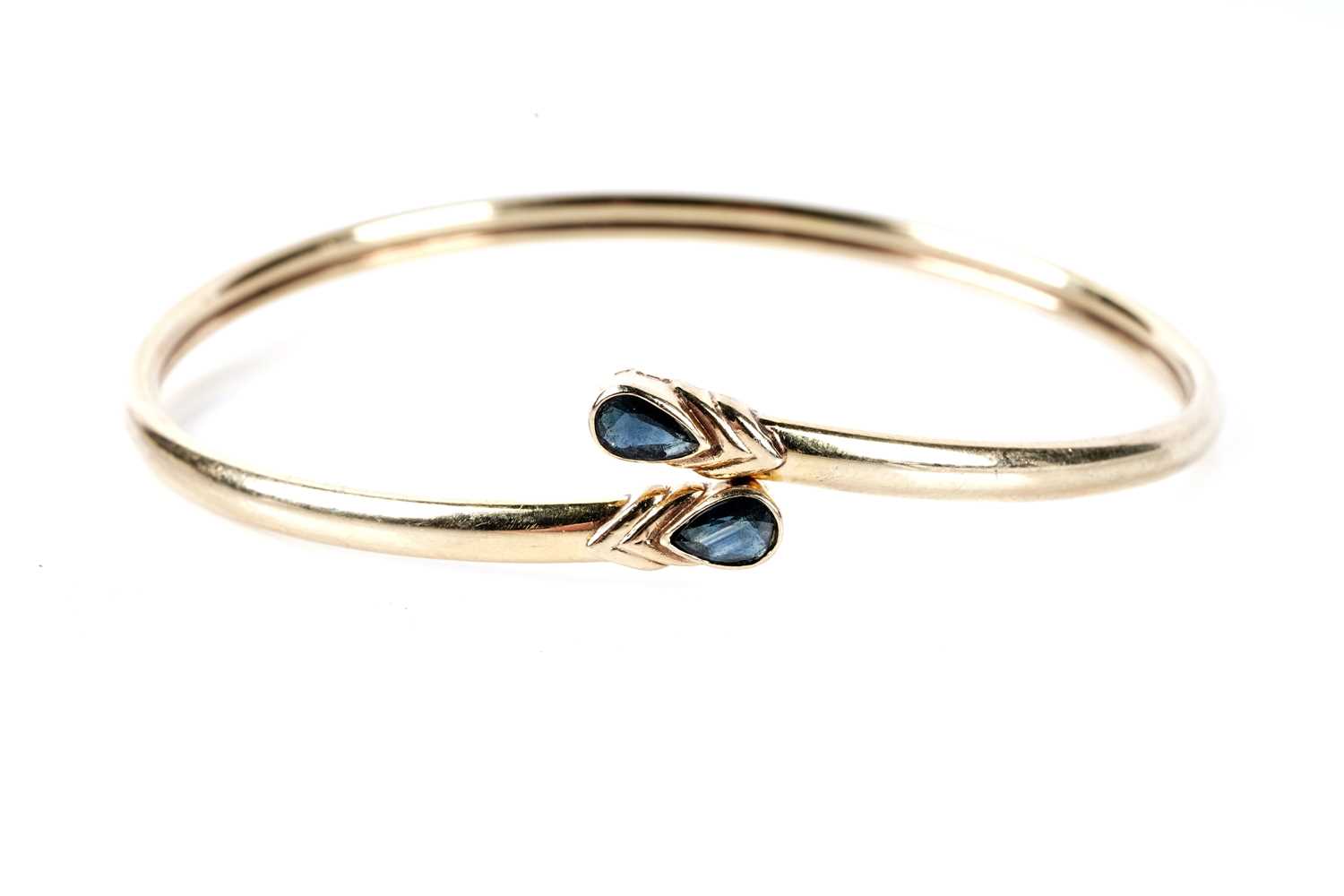 Lot 173 - A sapphire set crossover bangle