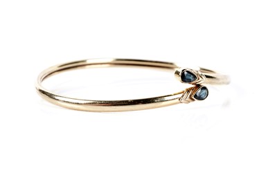 Lot 173 - A sapphire set crossover bangle